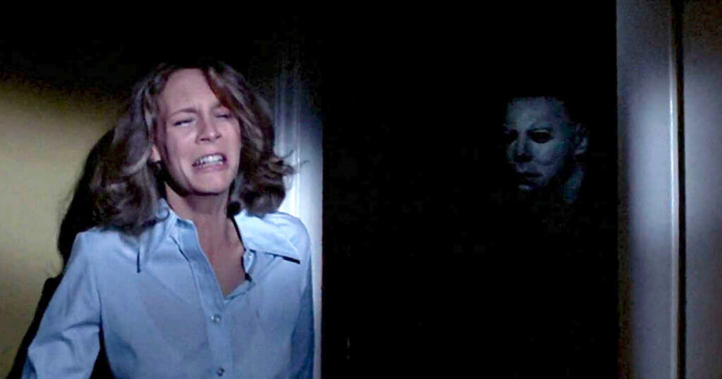 Jamie Lee Curtis sendo atacada pela vilão de Halloween em filme 