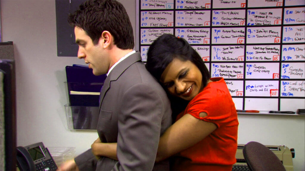 Personagens da Kelly abraçando o estagiário Ryan em cena de The Office